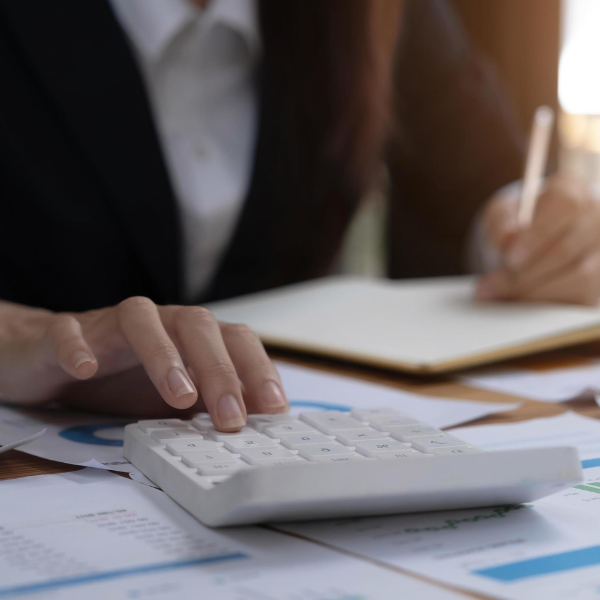 Pessoa calculando orçamento com calculadora e papéis